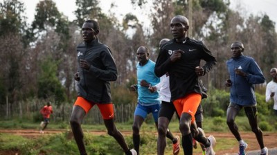 Kenyan athlete Eliud Kipchoge running among zebras and wildebeest